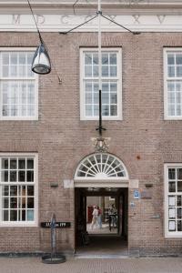 un edificio de ladrillo con dos personas caminando por la puerta en Stadsklooster Dordt Hotel&Hostel en Dordrecht