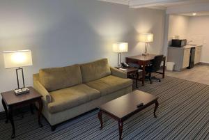 a living room with a couch and tables and a desk at Ramada by Wyndham London in London