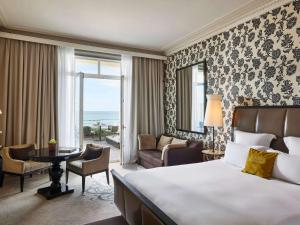 a hotel room with a bed and a living room at Le Grand Hotel de Cabourg - MGallery Collection in Cabourg
