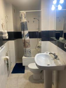 Un baño con lavabo, inodoro y ducha. en A casa da Tita, en Redondela