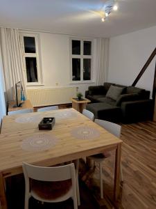 sala de estar con mesa de madera y sofá en Gästehaus Stern, en Schwabach