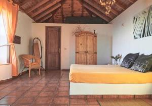 una camera con un grande letto e un soffitto in legno di Finca del Sur a Las Indias