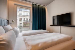 um quarto de hotel com duas camas e uma televisão em Motel One Brussels em Bruxelas