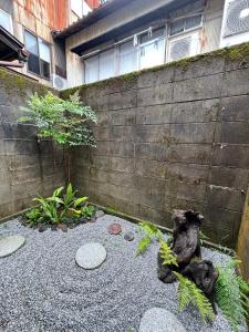 あざみ庵山中温泉 في كجا: حديقة بها اثنين من تماثيل الدب أمام الجدار