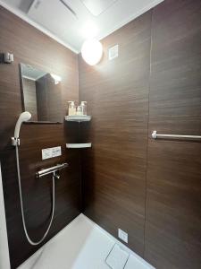 uma casa de banho com um chuveiro e um espelho. em あざみ庵山中温泉 em Kaga