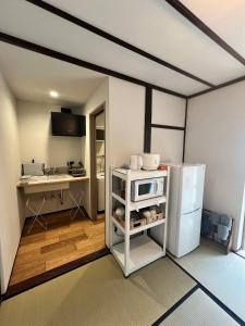 uma cozinha com um frigorífico branco e um lavatório em あざみ庵山中温泉 em Kaga