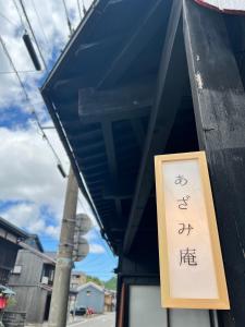 um sinal na lateral de um edifício em あざみ庵山中温泉 em Kaga
