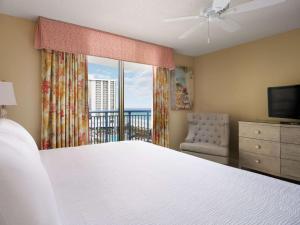 a bedroom with a bed and a view of the ocean at Kingston Plantation Condos in Myrtle Beach