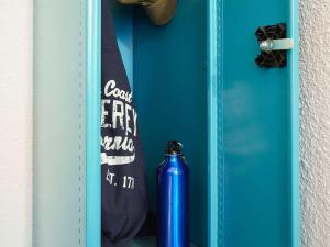 una botella de agua azul sentada junto a una puerta azul en hotelF1 Avignon Nord, en Sorgues