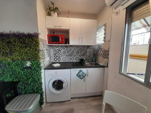 eine kleine Küche mit einer Waschmaschine und einem Waschbecken in der Unterkunft Apartamento una habitación supercéntrico in Torremolinos