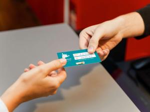 une personne remettant une carte de crédit à une autre personne dans l'établissement hotelF1 Nîmes Ouest, à Nîmes