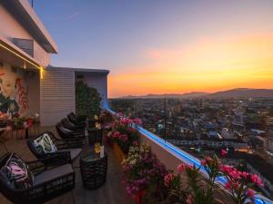 a balcony with a view of a city at sunset at Novotel Phuket City Phokeethra in Phuket Town