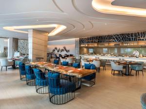 a restaurant with blue chairs and tables and a bar at Novotel Phuket City Phokeethra in Phuket