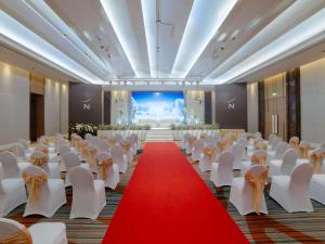 um salão de banquetes com cadeiras brancas e um tapete vermelho em Novotel Phuket City Phokeethra em Phuket