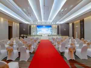 a banquet hall with white chairs and a red carpet at Novotel Phuket City Phokeethra in Phuket Town