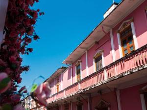 a pink building with windows and a balcony at Novotel Phuket City Phokeethra in Phuket Town