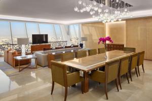 uma sala de jantar com uma mesa e cadeiras e um lustre em Hyatt Regency Riyadh Olaya em Riyadh