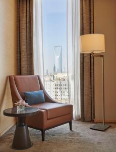 sala de estar con silla, mesa y ventana en Hyatt Regency Riyadh Olaya en Riad