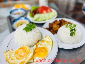trois assiettes de denrées alimentaires contenant du riz et des œufs sur une table dans l'établissement Villa - Hotel Nam Khang 2 Dalat, à Đà Lạt