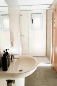 a white bathroom with a sink and a shower at New Art Hostel - Albergue Juvenil in Palma de Mallorca