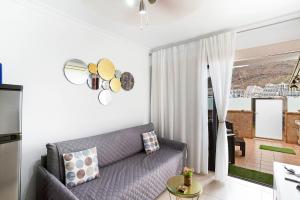a living room with a couch and a window at Alohe Puertorico View in Puerto Rico de Gran Canaria