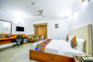 ein Hotelzimmer mit einem Bett, einem Schreibtisch und einem Computer in der Unterkunft FabHotel Exotica Galleria Market, Gurgaon in Gurgaon