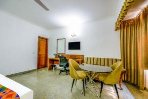 a room with a desk and a table and chairs at Hotel Exotica Leisure Valley, Gurgaon in Gurgaon