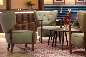 un grupo de sillas y una mesa en una habitación en Radisson Blu Royal Garden Hotel, Trondheim, en Trondheim