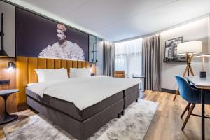 um quarto de hotel com uma cama grande e uma secretária em Radisson Blu Royal Garden Hotel, Trondheim em Trondheim