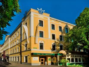 un edificio amarillo con un reloj encima en Parkhotel Graz - Traditional Luxury en Graz