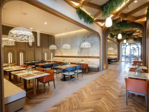 um restaurante com pisos e mesas e cadeiras de madeira em The First Collection Waterfront em Dubai