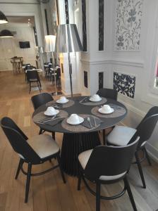 uma mesa num quarto com cadeiras e uma sala de jantar em Hôtel de Paris em Besançon