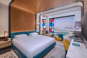 Andaz by Hyatt – Palm Jumeirah في دبي: غرفة نوم بسرير كبير ونافذة كبيرة