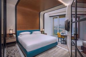 a bedroom with a bed and a desk and a television at Andaz by Hyatt – Palm Jumeirah in Dubai