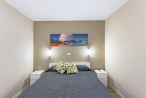 a bedroom with a bed with two night stands and a painting at Enjoy in Puerto Rico de Gran Canaria +14 photos