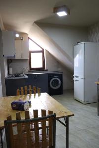 a kitchen with a table and a white refrigerator at Lucy in Garni