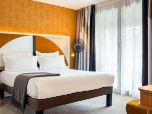 - une chambre avec un grand lit et une grande fenêtre dans l'établissement Le Saint Gervais Hotel & Spa Handwritten Collection, à Saint-Gervais-les-Bains