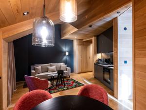 a kitchen and living room with a table and chairs at Swissôtel Resort Kolasin in Kolašin