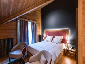 een slaapkamer met een groot bed en 2 stoelen bij Swissôtel Resort Kolasin in Kolašin