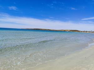 a beach with the ocean and a blue sky at Da Tziu Efisiu Mare e Relax nel Sinis in Baratili San Pietro