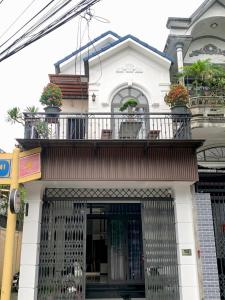 ein Gebäude mit einem Balkon mit Topfpflanzen darauf in der Unterkunft Êm Home 3 Phòng Ngủ in Hue