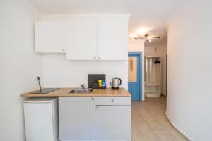a kitchen with white cabinets and a sink at Yoga House Kaş in Kaş