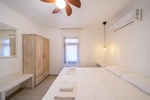 a white bedroom with a large bed and a window at Yoga House Kaş in Kaş