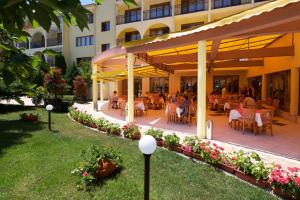 un restaurante en un complejo con mesas y sillas en Yavor Palace Hotel - All Inclusive, en Sunny Beach