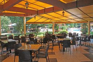 un restaurante con mesas, sillas y sombrillas amarillas en Yavor Palace Hotel - All Inclusive, en Sunny Beach