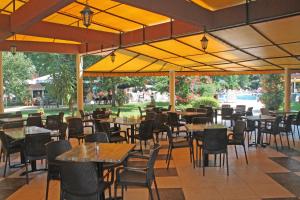 a restaurant with tables and chairs and yellow umbrellas at Yavor Palace Hotel - All Inclusive in Sunny Beach