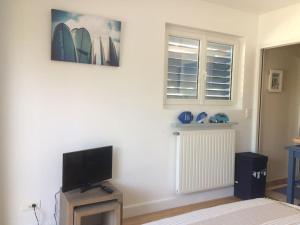 un salon avec une télévision à écran plat sur un mur dans l'établissement Cap Océan-Studio, à Capbreton