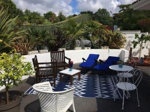 un patio avec des chaises, des coussins bleus et des tables dans l'établissement Cap Océan-Studio, à Capbreton