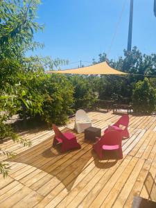 una terrazza con sedie, tavolo e ombrellone di Monte do Bidé Private Farm Peace and Nature a Setúbal