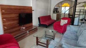 ein Wohnzimmer mit roten Stühlen und einem Flachbild-TV in der Unterkunft Sincer Otel in Kusadası